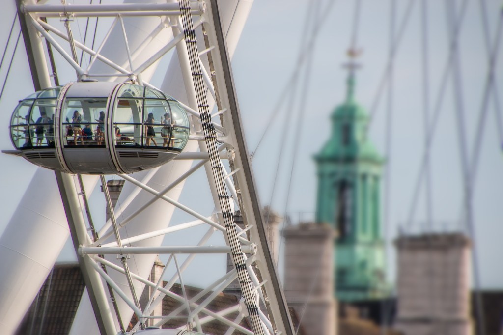 Morsin Living a ferris wheel the London Eye with people on it and city in the background