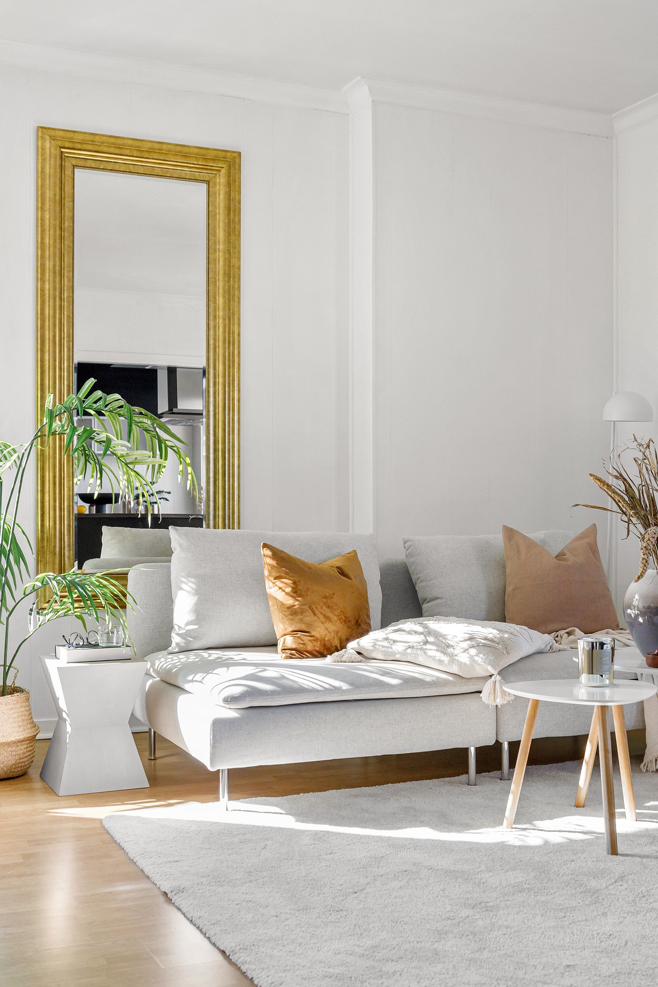 Morsin Living living room with a with a modern couch and gold mirror and orange cushions living modern space